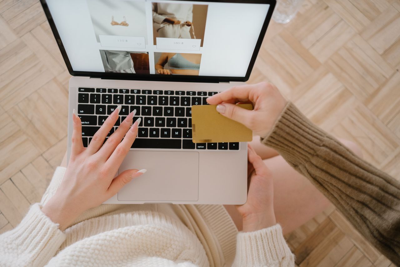 creative-02 Une personne faisant ses achats en ligne sur un ordinateur portable avec une carte bancaire, mettant en avant la simplicité du e-commerce.